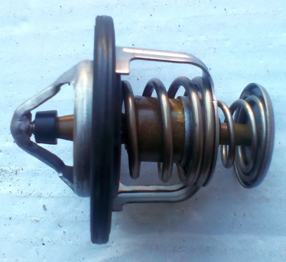 Automotive engine cooling thermostat with its spring and valve visible