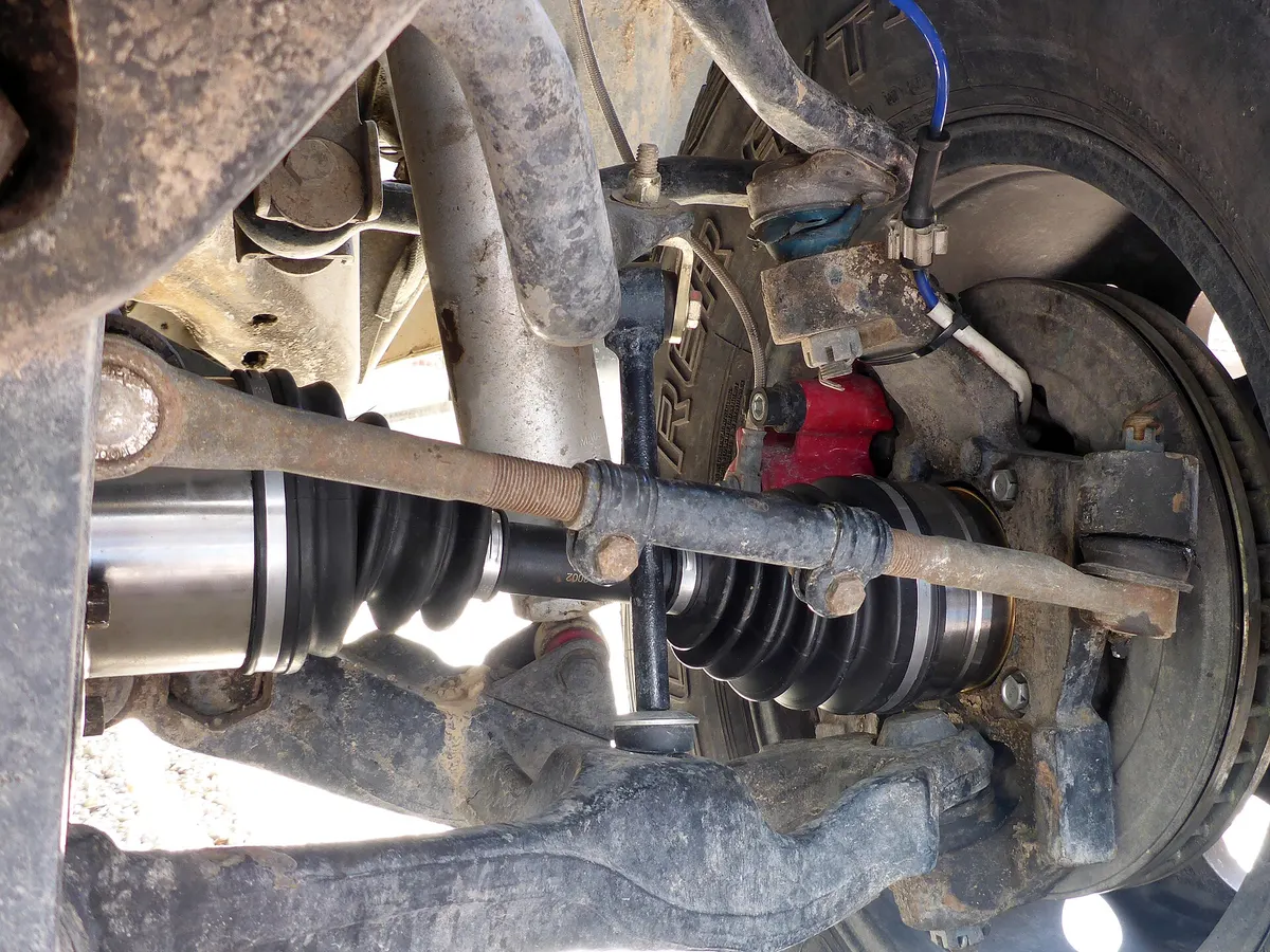 Front suspension with control arm, tie rod, CV axle and brake assembly visible