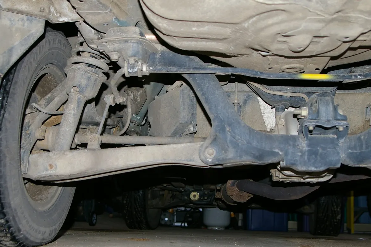 Underside view of a vehicle's rear suspension arms and shock absorber